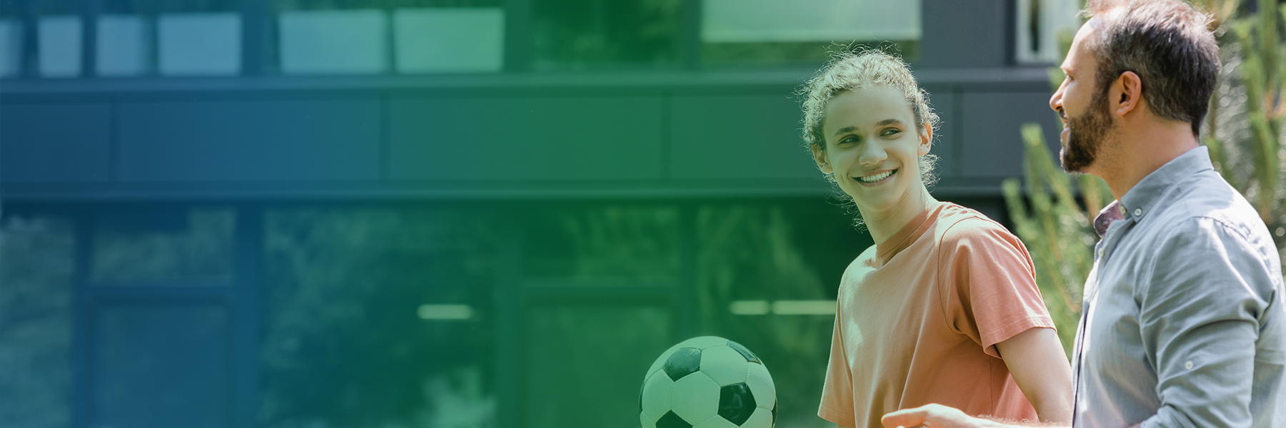 parent talking to child holding a soccer ball